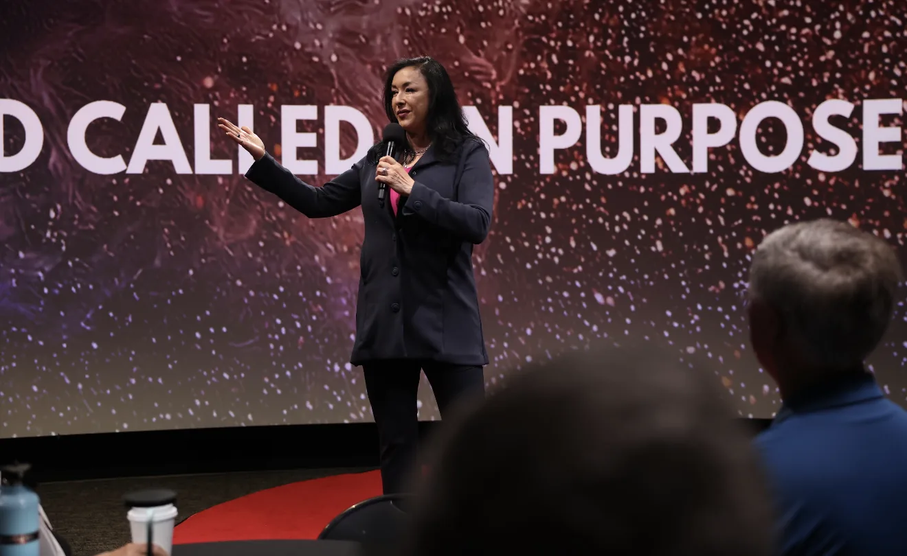 Blanca Criner speaking on stage to an audience